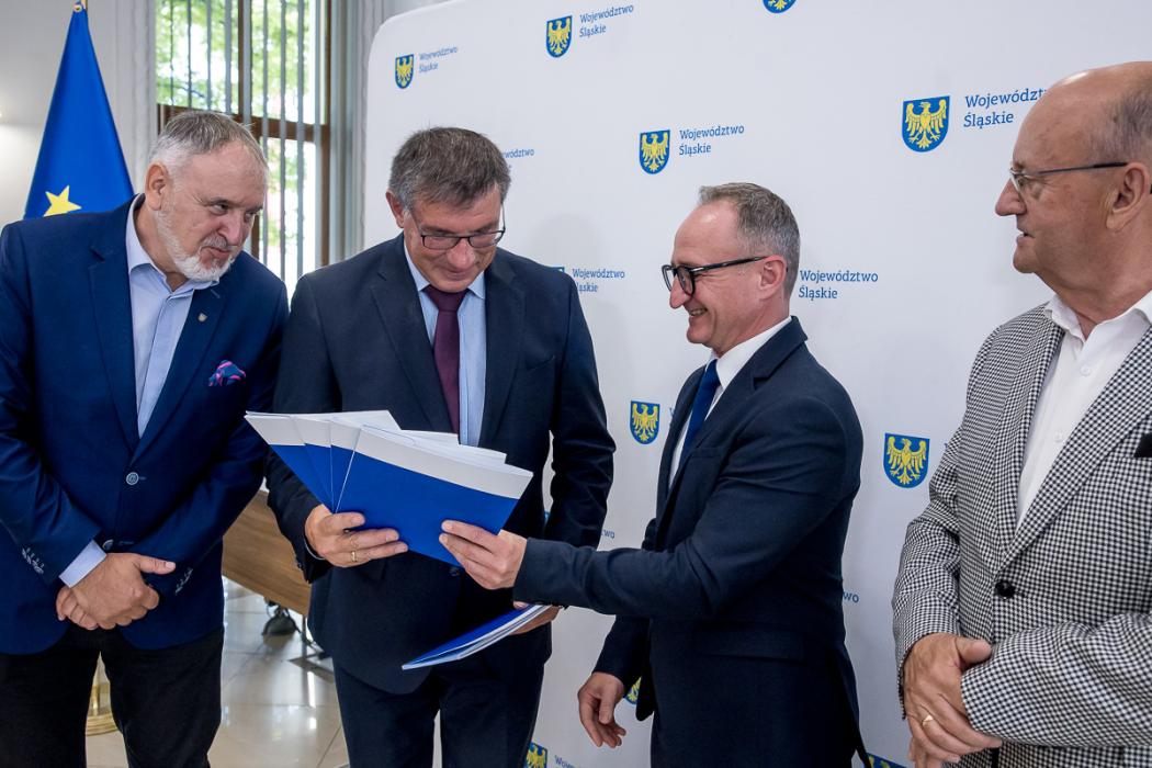 Uczestnicy uroczystości odbierają listy gratulacyjne. 