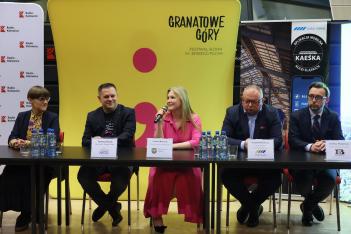 Uczestnicy konferencji siedzą przy stole. 
