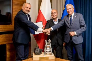 Wojciech Kamiński, Prezes Zarządu PKW S.A., Robert Kropiwnicki, Sekretarz Stanu w MAP oraz Wojciech Saługa, Marszałek Województwa Śląskiego. W tle flagi. Na stole makieta kopalni z bryłką węgla. 
