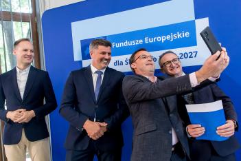 Osoby wręczające oraz beneficjenci odbierający listy gratulacyjne. 