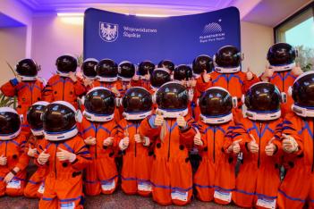 Dzieci w strojach astronautów pozujące wspólnie na tle niebieskiej ścianki województwa śląskiego 