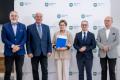 Uczestnicy uroczystości odbierają listy gratulacyjne. 