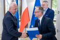 Uczestnicy uroczystości odbierają listy gratulacyjne. 