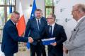 Uczestnicy uroczystości odbierają listy gratulacyjne. 