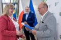Uczestnicy uroczystości odbierają listy gratulacyjne. 