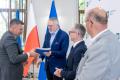 Uczestnicy uroczystości odbierają listy gratulacyjne. 