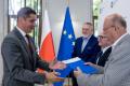Uczestnicy uroczystości odbierają listy gratulacyjne. 