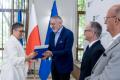 Uczestnicy uroczystości odbierają listy gratulacyjne. 