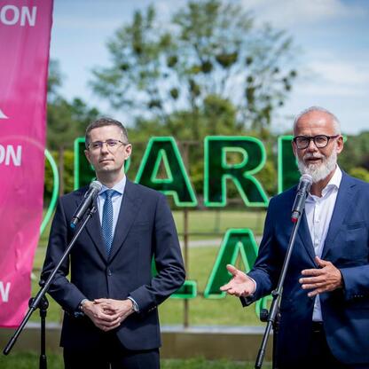 Dwóch mężczyzn w mikrofonach przed Tauron Park Śląski. (wygenerowano przez AI)