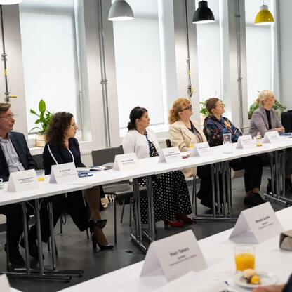 Sześć edukatorów i ekspertów dyskutuje w konferencji o roli edukacji w regionie. (wygenerowano przez AI)